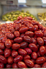 Red olives close up on market, food background