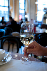 Lifestyle of beautiful Vienna, glass of white dry Austrian wine served in old Viennese-style cafe in Vienna, Austria