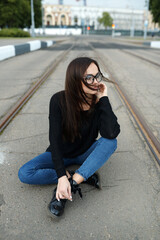 Young girl in glasses walking in summer in the city. The concept of lifestyle and fashion