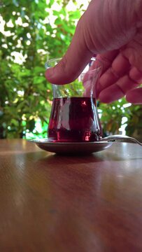 Close up view of young teen girl drinking tea in a cafe. Slow motion.It fills Turkish tea into a glass special to the Turks.