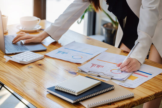 Young Economists Or Accountants Or Financiers And Investors Are Reviewing Budget Documents And Using Computers To Study Impact And Risk Assessments On Corporate Investment Management.