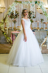 Fototapeta na wymiar young caucasian brazilian bride at her wedding with decorated background, makeup and hairstyle.