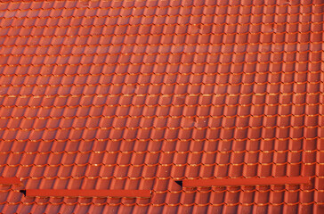 Brown corrugated metal profile roof installed on a modern house. The roof of corrugated sheet. Roofing of metal profile wavy shape. Modern roof made of metal. Metal roofing.