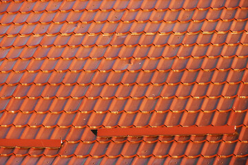 Red corrugated metal profile roof installed on a modern house. The roof of corrugated sheet. Roofing of metal profile wavy shape. Modern roof made of metal. Metal roofing.
