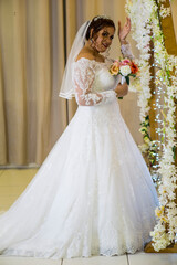 Fototapeta premium plus size young caucasian brazilian bride at her wedding with decorated background, makeup and hairstyle.
