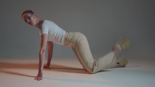 Flexible dancing young woman short haired performing sexy passionate vogue femme dance on studio floor. ProRes codec