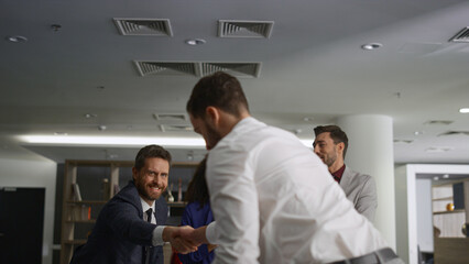 Business partners shake hands making agreement in financial company office.