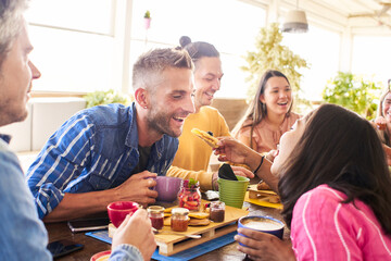 Group of Happy friends having breakfast in the restaurant