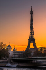 Paris, France - November 6, 2020: Eiffel tower and Saint-Trinite Orthodox Cathedral at sunset in Paris
