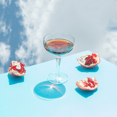 Juicy red drink pomegranate with sky background. Summer fruit aesthetic party drink concept.