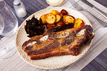 Fresh grilled beef rib steak, churrasco de ternera, served on table with roasted potatoes and...