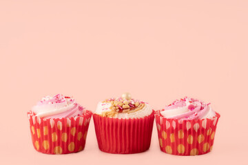 three berry muffins in red wrappers on a pink background high-quality photos for calendar and cards. Space for text