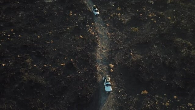 Aerial view of jeeps driving over volcanic rocks. Erta Ale, Ethiopian volcano in Afar Depression