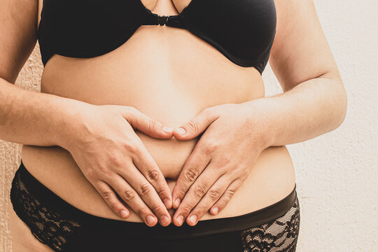 Cuerpo diverso. Mujer en ropa interior, formando coraz&oacute;n con las manos posadas sobre su abdomen.