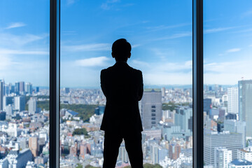 Fototapeta premium 高層ビルを眺めるビジネスマンの背中