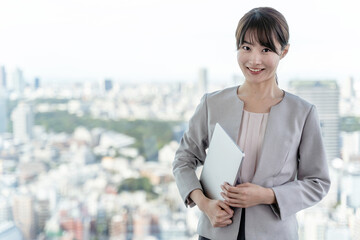高層ビルを背景に立つビジネスウーマンのポートレート © taka