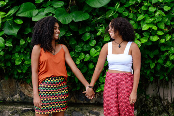 Happy lesbian couple holding hands in the park