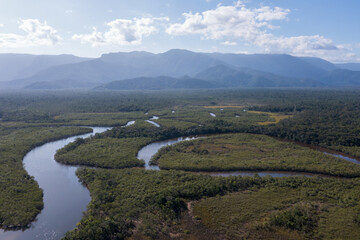 Fototapeta na wymiar imagem aérea das águas do rio itaguaré sobre a mata atlântica com algumas montanhas ao fundo 