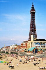 English seaside summer holiday. People sunbathing on Blackpool Beach beneath Blackpool Tower,...