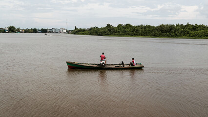 Fototapeta na wymiar Residents use traditional boat or speed boats to cross the river. Local people.