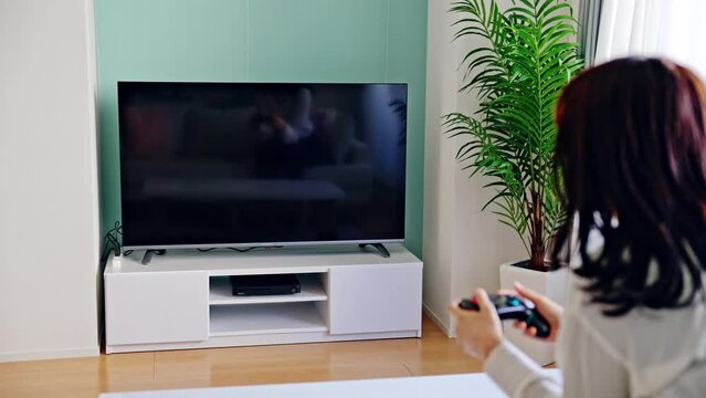 テレビゲームで遊ぶ女性