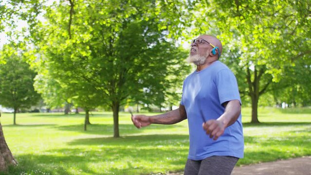 Healthy senior black man exercises in a park with a skipping rope, in slow motion