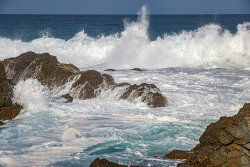 Rough Waves Breaking on Rocks on Coast