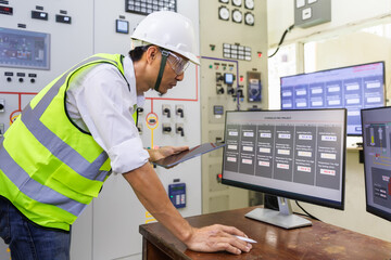 Experienced electrician working in a power plant control room. Engineer working in electric power...