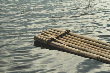 A raft made of dry bamboo is floating above the lake