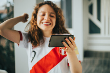 Plano cerrado de mujer celebrando mirando su teléfono. Concepto de gente y reacciones, deporte. © artrolopzimages