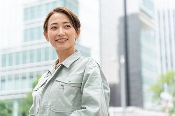 空を見る作業着を着た爽やかな日本人女性