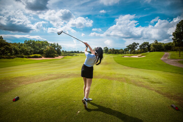 Professional woman golfer teeing golf in golf tournament competition at golf course for winner.	
