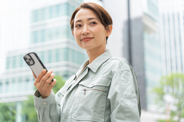 携帯を持ち空を見る見る日本人女性