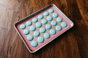 Bakery. Making macaroons. Blue macarons ready for baking lie on a tray on a wooden table. Biscuit