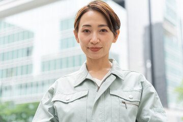 カメラを見る作業着を着たショートヘアーの日本人女性