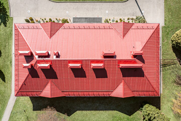 aerial view of house with red corrugated metal sloping roof, chimneys and ventilation pipes