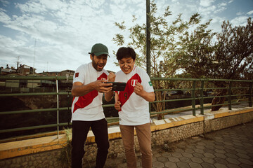 Dos fanáticos de Perú celebran un gol mirando su teléfono. Concepto de personas y deportes.