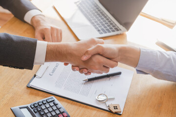 Fototapeta premium Close up hand of asian young male new landlord, tenant or rental handshake with home, apartment agent or realtor man after bank approved mortgage, loan signed purchase contract. Property of financial.