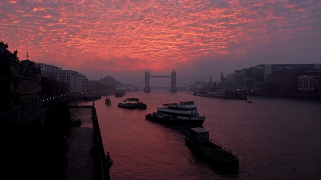 Vibrant, dramatic sunrise clouds above Tower Bridge and the River Thames in London, England