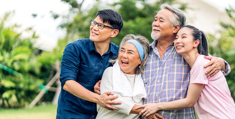 Portrait enjoy happy smiling love multi-generation asian big hug family.Senior mature father and elderly mother with young adult woman and son outdoor in park at home.insurance concept