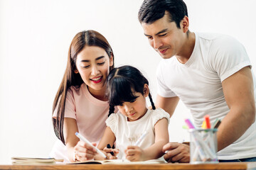Obraz na płótnie Canvas Portrait happy love asian family father and mother with little asian girl learn and study on table.Mom and dad with asian young girl writing with book make homework in homeschool at home.Education