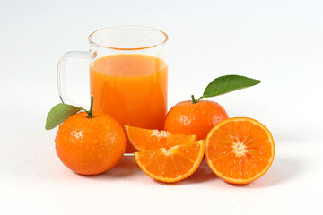 Orange, halved oranges squeezed into juice in clear glass, healthy fruit, mandarin oranges, vitamin C, white background with refreshing drop of water
