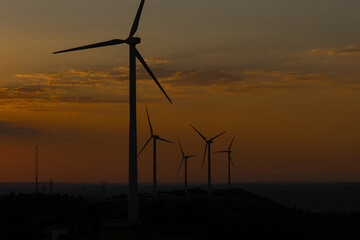 Sunset over a windmill park. An example of renewable energy, clean nature and a sustainable future. Earth Day