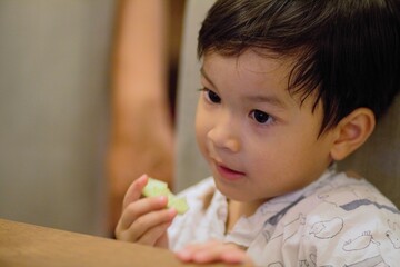 appy little Asian todler boy at dining table.Happy chld