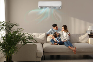 Happy family resting under air conditioner on beige wall at home - obrazy, fototapety, plakaty