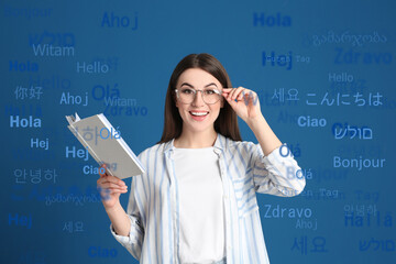 Portrait of happy translator and greeting words in different foreign languages on light blue background © New Africa
