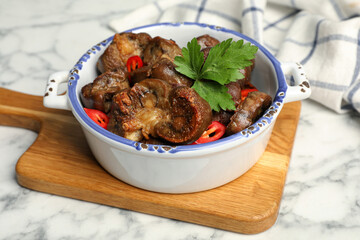 Bowl with delicious kidneys, pepper and parsley on white marble table