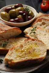 Tasty bruschettas with oil and thyme on plate, closeup