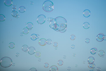 Many big soap bubbles. Colorful soap bubble on the blue sky.