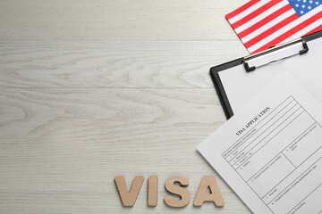 Flat lay composition with American flag and visa application form on white wooden table, space for text